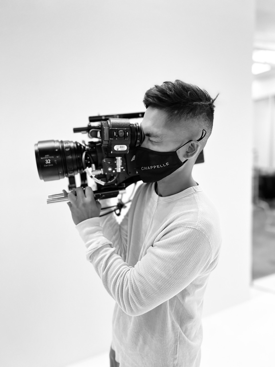 Alvin Octoman looking through a cinema camera